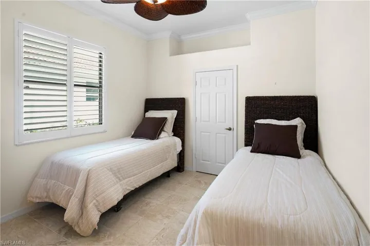 Bedroom featuring crown molding, ceiling fan, baseboards, and light tile patterned flooring