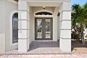 Entrance to property featuring french doors and stucco siding