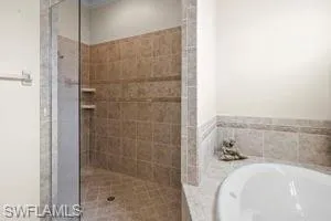 Bathroom with a stall shower and a bath