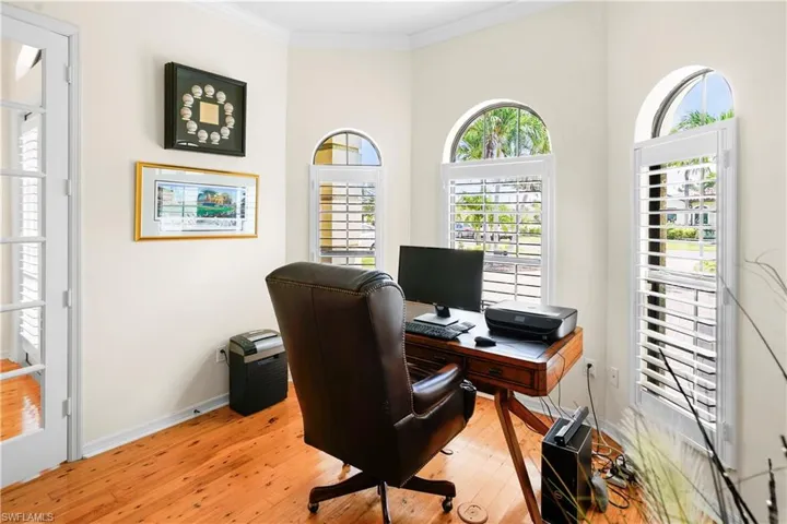 Office space with light wood-style floors, ornamental molding, and baseboards