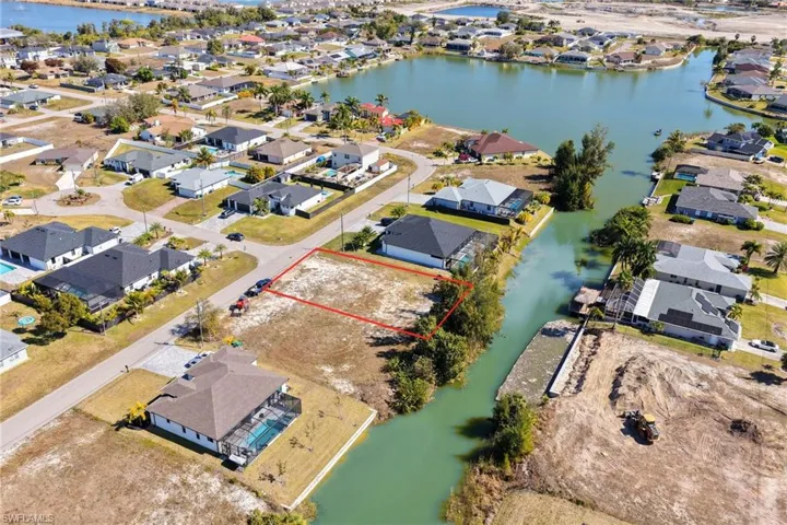 Aerial view of residential area with a nearby body of water and property boundaries highlighted