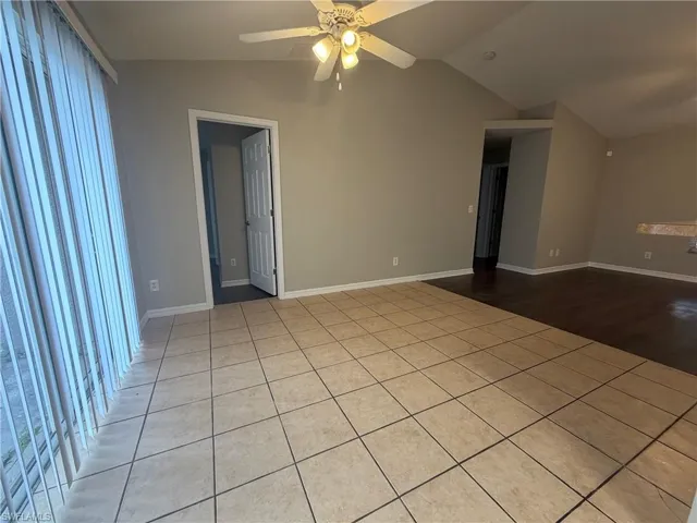 Unfurnished room with vaulted ceiling, ceiling fan, and light tile patterned floors