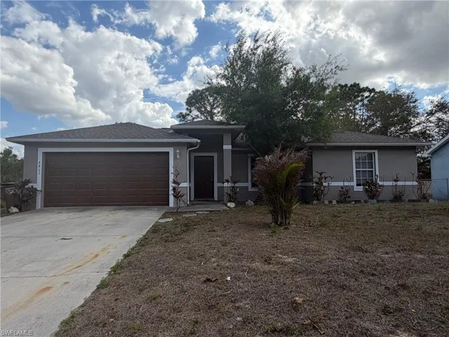 View of front of home featuring stucco siding, driveway, and an attached garage
