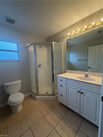 Bathroom featuring vanity, a stall shower, and light tile patterned floors