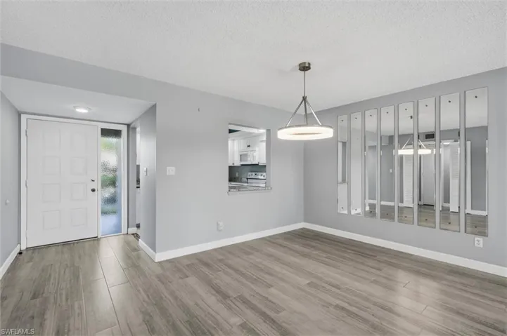 Unfurnished dining area with a textured ceiling and wood finished floors