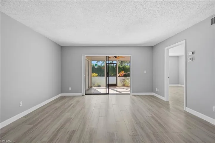 Empty room featuring a textured ceiling and light wood-type flooring