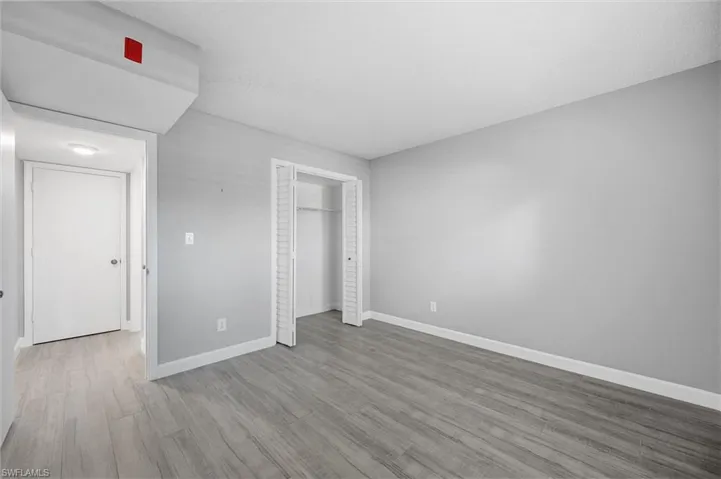 Unfurnished bedroom featuring light wood-type flooring and a closet
