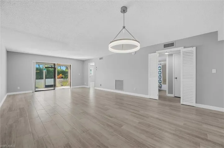 Unfurnished living room featuring light wood-style flooring and a textured ceiling