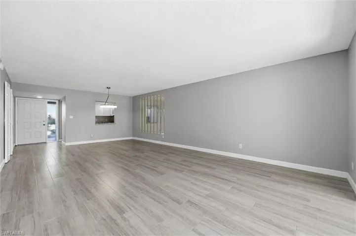 Unfurnished living room featuring light wood-style floors and a textured ceiling