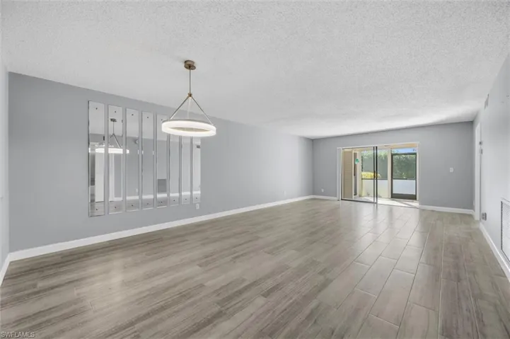Spare room featuring wood finished floors and a textured ceiling