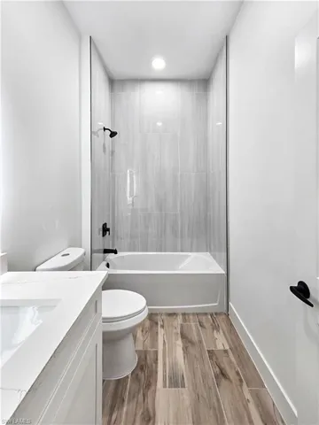 Bathroom with vanity, light wood finished floors, and bathtub / shower combination