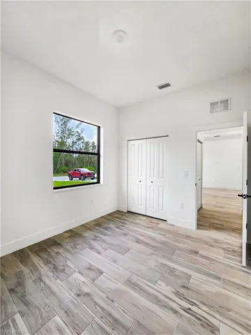 Unfurnished bedroom with wood finish floors and a closet