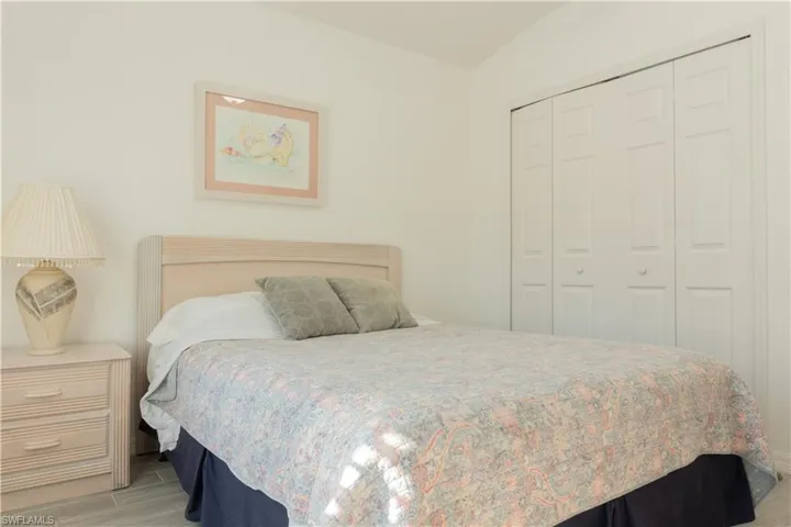 Bedroom featuring vaulted ceiling, a closet, and light wood-type flooring
