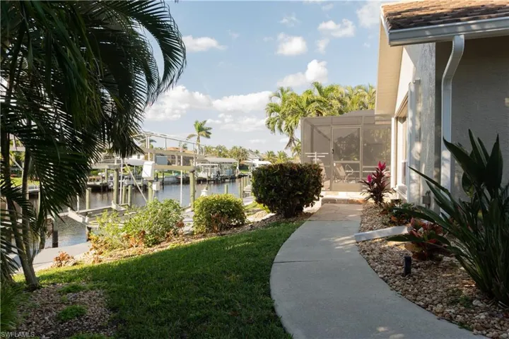 View of yard with a water view and a dock