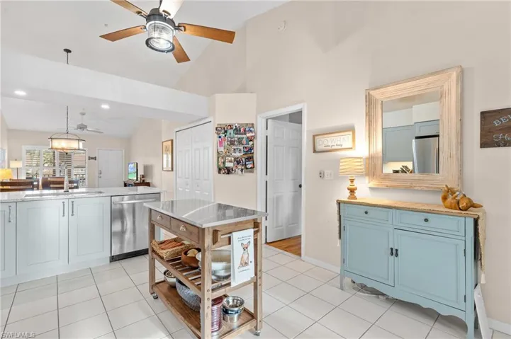 Kitchen featuring light tile patterned floors, stainless steel appliances, blue cabinets, and sink