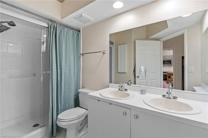 Bathroom with walk in shower, vanity, and toilet