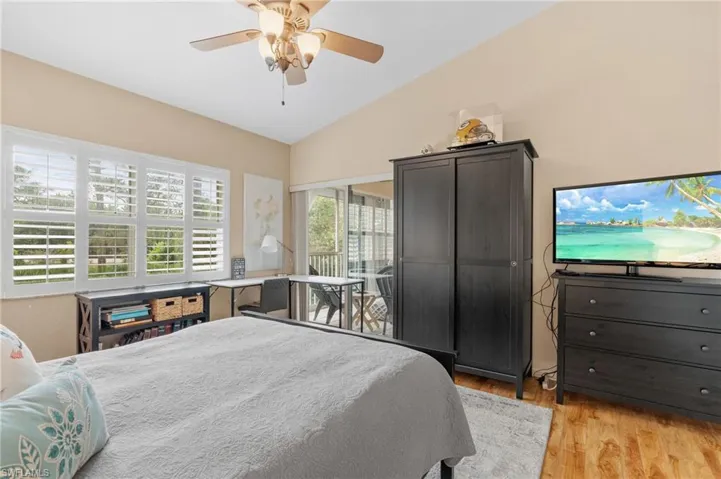 Bedroom featuring ceiling fan, light hardwood / wood-style floors, and vaulted ceiling