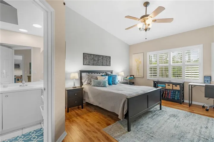 Bedroom with ceiling fan, lofted ceiling, sink, and light hardwood / wood-style flooring