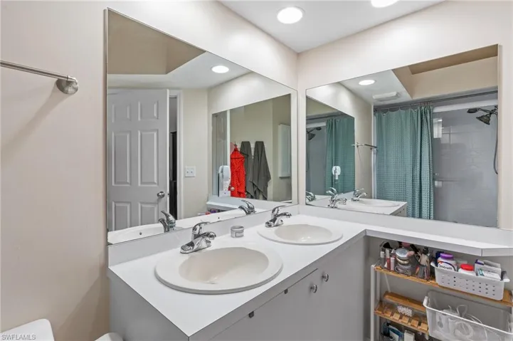 Bathroom with a shower with shower curtain and vanity