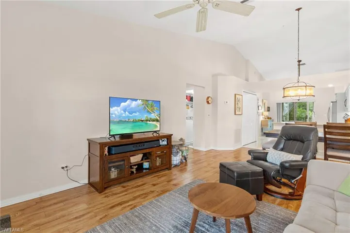 Living room featuring vaulted ceiling, light hardwood / wood-style flooring, and ceiling fan