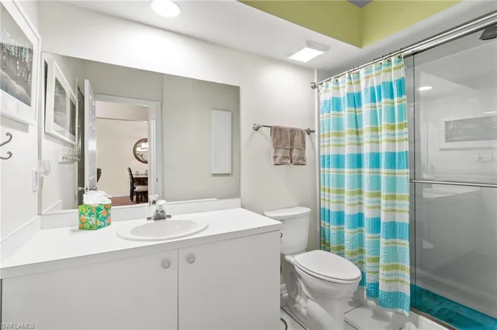 Bathroom with vanity, curtained shower, and toilet