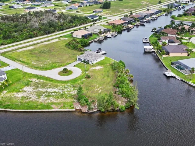 Expansive waterfront lot situated at a canal intersection, featuring cleared land and direct canal access