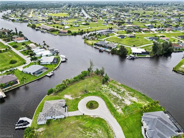 Waterfront parcel featuring a concrete driveway and cul-de-sac access