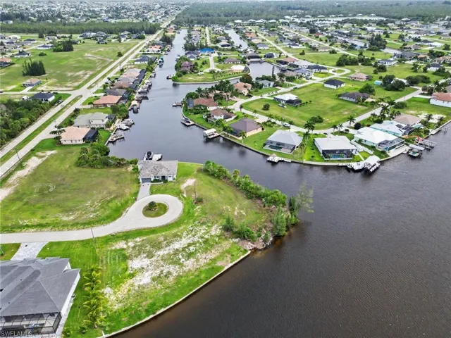Waterfront property featuring a private boat dock, direct canal access, and a circular driveway