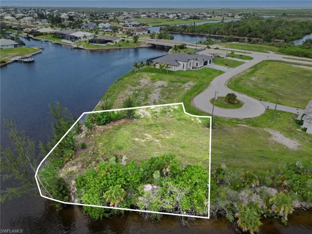 Cleared parcel with canal frontage, featuring a cul-de-sac entrance and surrounding mature vegetation