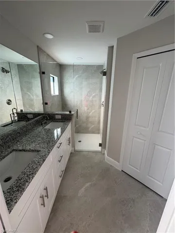Bathroom with a shower stall and double vanity