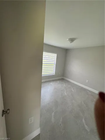 Unfurnished room with baseboards and unfinished concrete floors