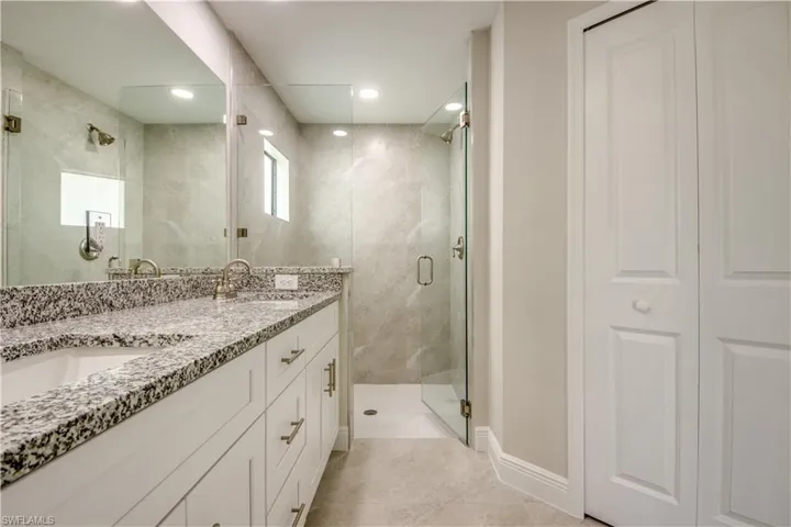 Full bathroom with double vanity, a stall shower, and tile patterned floors