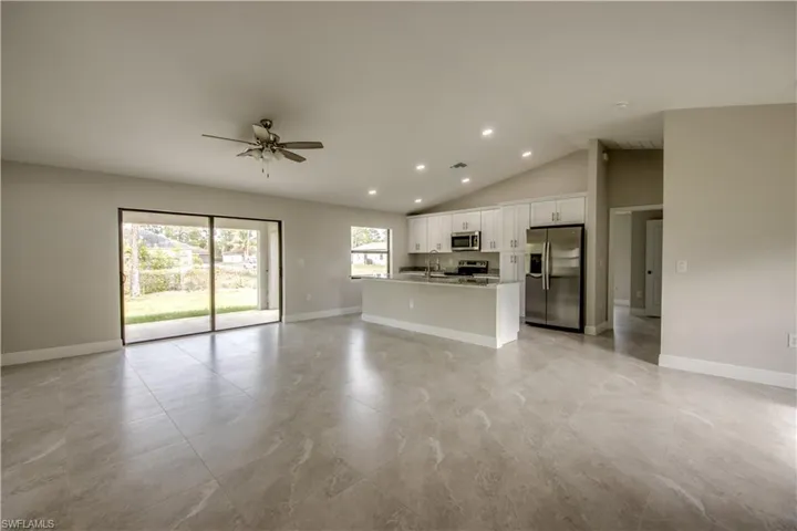 Unfurnished living room with a ceiling fan, recessed lighting, and vaulted ceiling
