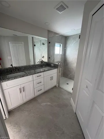 Bathroom with a shower stall and double vanity