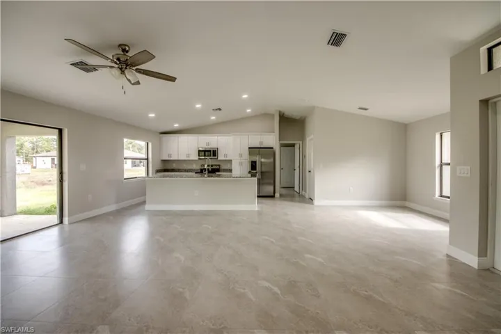 Unfurnished living room with ceiling fan, lofted ceiling, and recessed lighting