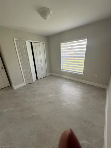 Unfurnished bedroom featuring a closet and concrete flooring