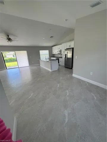 Unfurnished living room with lofted ceiling and ceiling fan