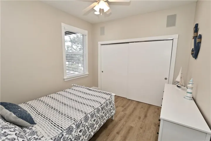 Bedroom featuring light wood-type flooring, ceiling fan, and a closet