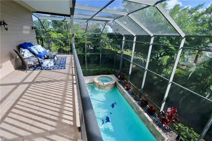 Integrated pool / hot tub featuring a sunroom and a lanai