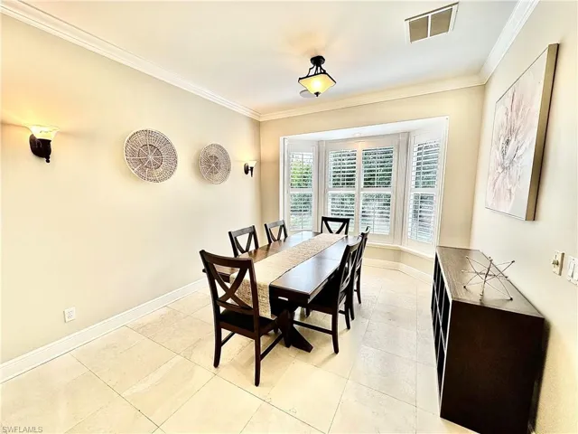 Dining space with ornamental molding and light tile patterned floors