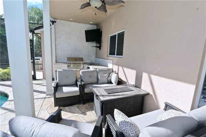View of patio / terrace with an outdoor kitchen and area to lounge, ceiling fan, and an outdoor pool