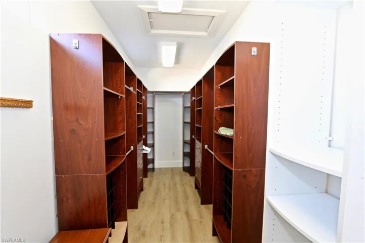 Walk in closet featuring light wood-type flooring and attic access