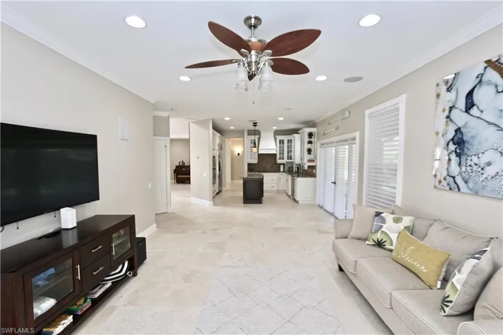 Living area with recessed lighting, ornamental molding, and ceiling fan