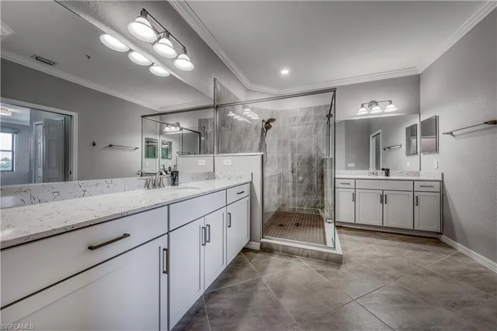 Bathroom featuring an enclosed shower, vanity, tile patterned floors, and ornamental molding