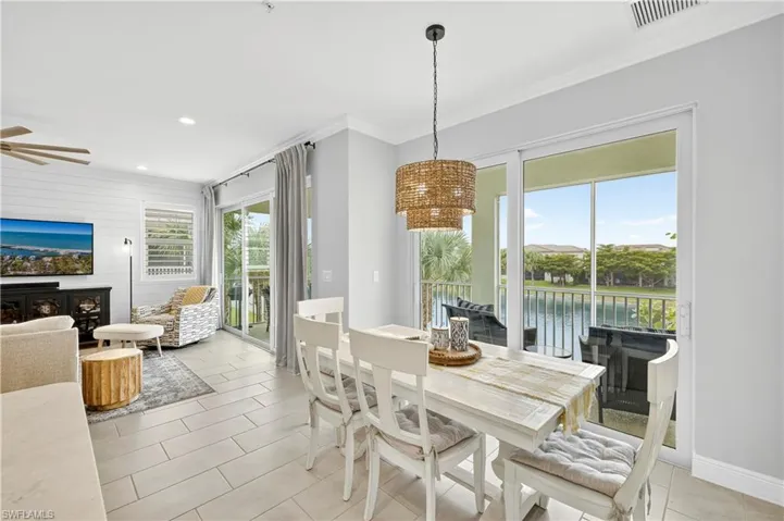 Dining room featuring ornamental molding, light tile patterned flooring, recessed lighting, a water view, and wooden walls