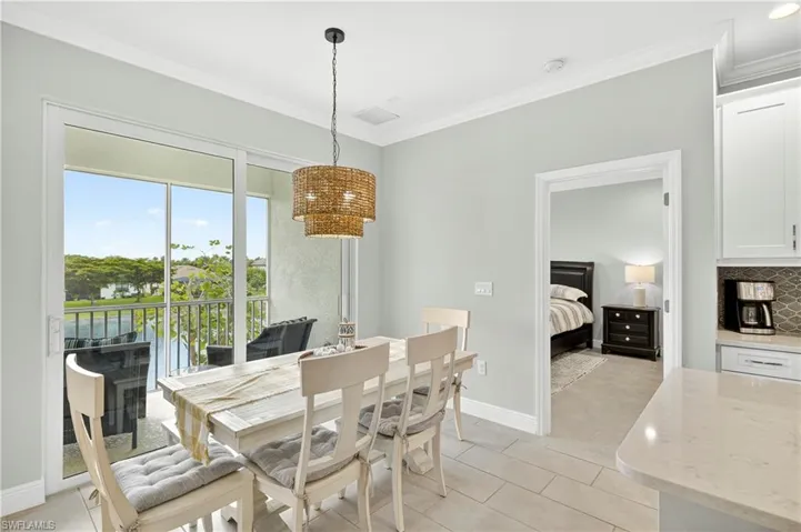 Dining area with ornamental molding and light tile patterned flooring