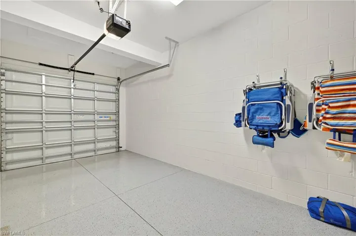 Garage featuring concrete block wall and a garage door opener