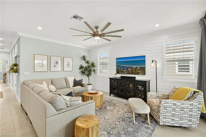 Living room featuring light tile patterned floors, healthy amount of natural light, crown molding, recessed lighting, and a ceiling fan
