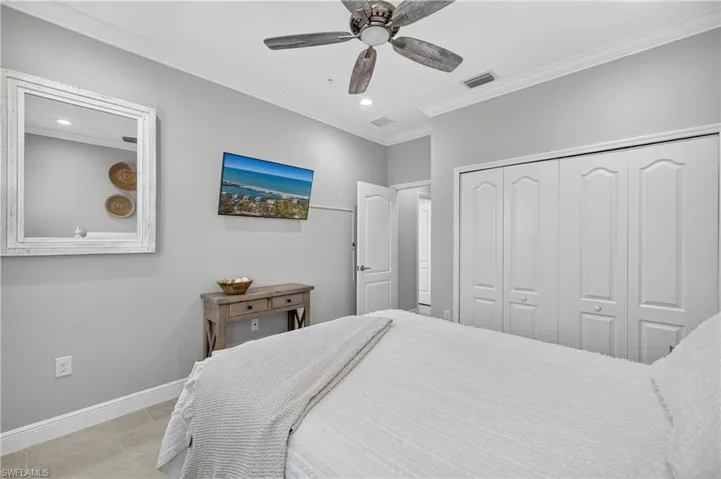 Tiled bedroom featuring ornamental molding, a ceiling fan, a closet, and recessed lighting