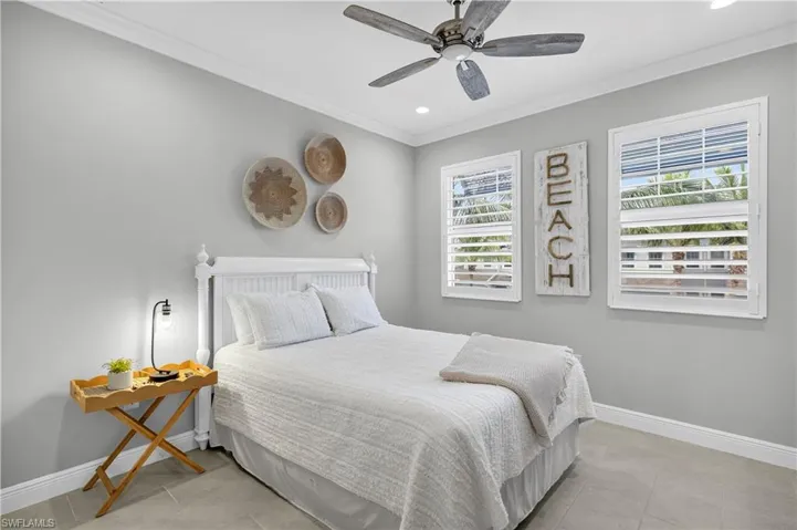 Bedroom with ornamental molding, multiple windows, a ceiling fan, light tile patterned floors, and recessed lighting
